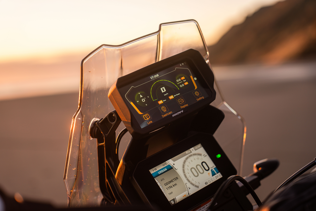 INNOVV N2 smart motorcycle display mounted on motorcycle dashboard at sunset