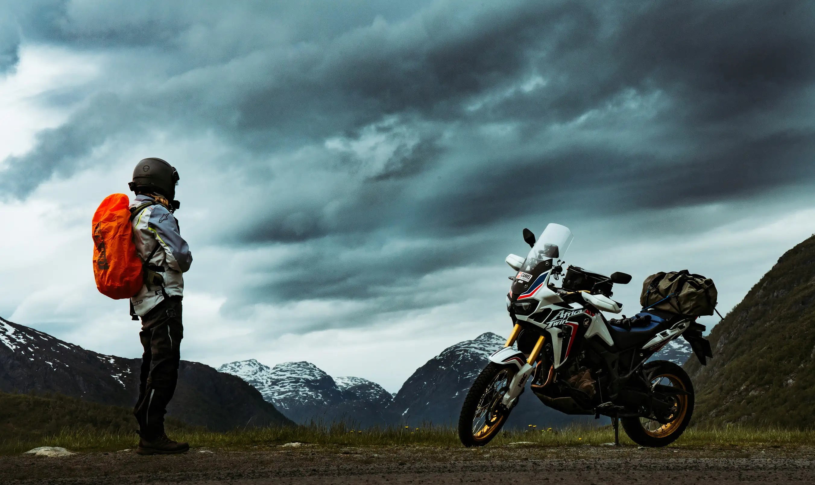 Motorcycle rider taking a break during a summer mountain road trip with adventure motorcycle